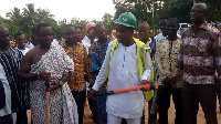 Francis Kwasi Bonzo (white) holding a pick axe