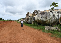 Aziz Alibhai walks past the wreckage of aeroplanes