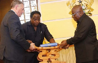 President Akufo-Addo presenting a gift to Mr. Pojolas (left), Out-Going French Ambassador to Ghana