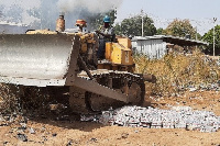 A heavy duty equipment crashing the cartons of milk from the school