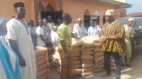 Suleiman Salifu (in smock) making the donation of 60 bags of cement