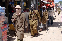 Armed al-Shabab fighters patrol Bakara Market in Mogadishu, Somalia