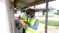 ECG personnel reading a meter in a home at Krobo