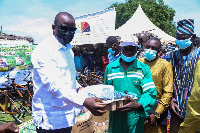 Samuel A. Jinapor presenting the item to one of the farmers