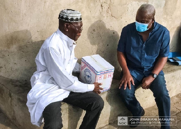 John Mahama presenting relief item to a man at Nima