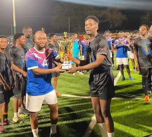 Mr Eazi presents the trophy to King Promise