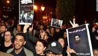 Protesters carried signs with detained journalist Omar Radi's picture in a rally