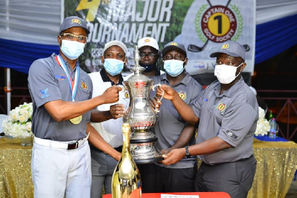 Torgah (left) receiving the trophy from Appiah (second left) and other executives