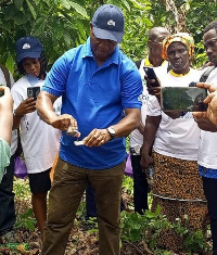 Daniel Attivor, the facilitator demonstrating and testing the soil acidity to participants