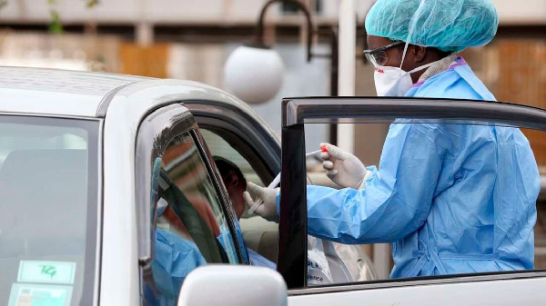 A lab attendant collects samples for Covid-19 testing from a man inside his car. PHOTO | FILE | NMG