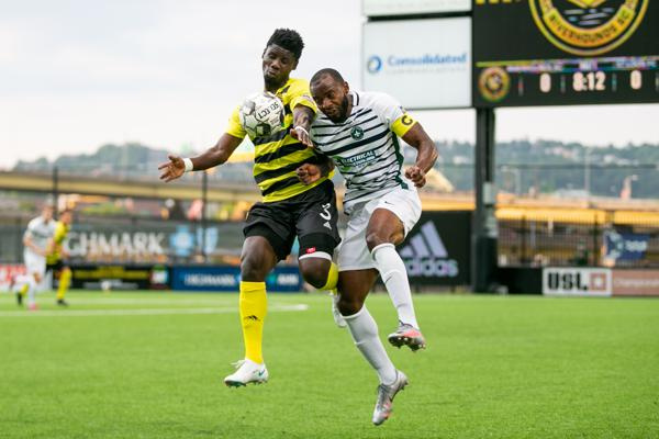 Ropapa Mensah (yellow) battling for the ball