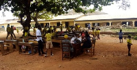 Students at the Agona Swedru Methodist “B” School learn outside their classroom due to the stench