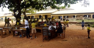 Students at the Agona Swedru Methodist “B” School learn outside their classroom due to the stench