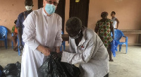 Rev. Father Campbell presenting the items to the lepers