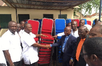 CEO of The Community Hospitals (TCH) Group, Alexander Akwasi Acquah presenting items to church