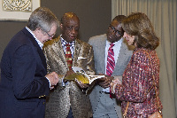 Dr Thomas Mensah holding his autobiography as he explains things to some of the audience present