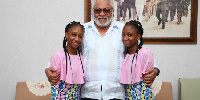 The twins in a photograph with former President John Rawlings