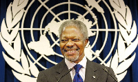 Kofi Annan standing in front of the United Naitons logo. Photograph: David Karp/AP