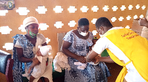 A health personnel administering  RTS,S, to a child