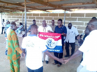 Rex Asanga (right) and Prof. Abole (left) hold the party's flag as supporters pray for victory