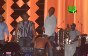 Shatta kneeling before Mr. Kennedy Agyapong on stage