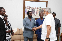 Former President Rawlings in a handshake with okoe Vanderpuije with others looking on