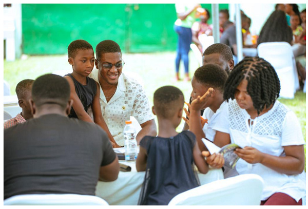 Sharaf Mahama reading with some of the children