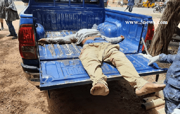 The robber lying in the bucket of the police pickup