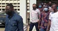 Owusu Bempah [in red and white shirt and black nose mask] returning from the court room