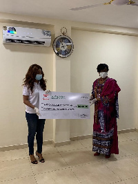 Brands Communication Manager, Sharon Anim presenting a cheque to National COVID-19 Trust Fund