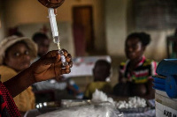 Children wait to be registered before a measles vaccination in DR Congo