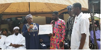 A government official hands over a cheque to a beneficiary during the presentation