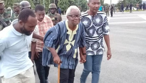 80-year-old leader of the group, Papavi Hogbedetor being escorted