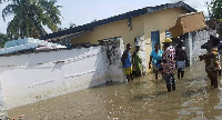 Residents salvaging their belongings through the flood to safety.