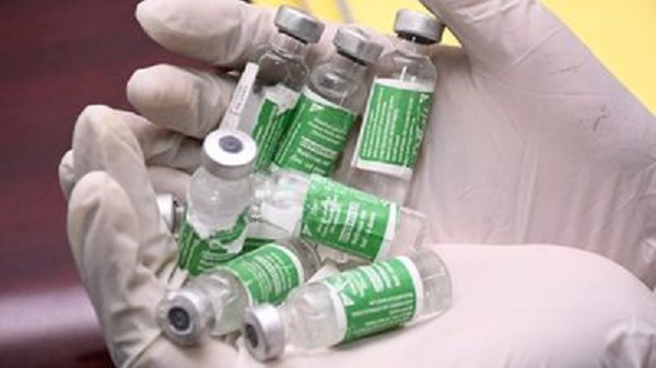 Dr. Warren Naamara of State House Health Monitoring Unit displays vials of the fake vaccine