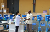 Heunghee Kim presenting the items to Dr Joseph Teye Nuertey