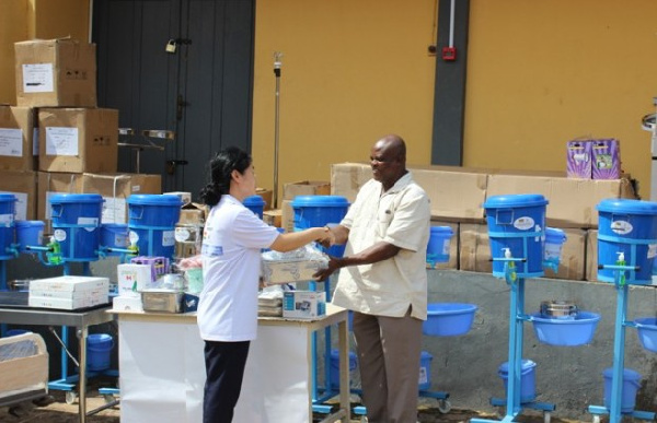 Heunghee Kim presenting the items to Dr Joseph Teye Nuertey