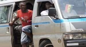 A bus conductor shouting for passengers