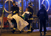 French fire brigade members aid an injured individual near the Bataclan concert hall following fata