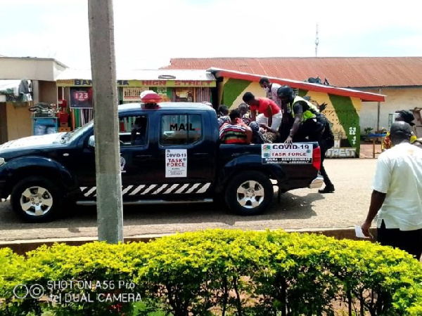 The arrested persons being loaded into the bucket of a police pick up truck