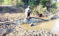 Mr Aboubaka Iddrisu using the solar pumps to irrigate his crops