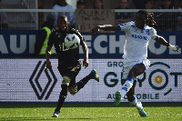 Gideon Mensah (in white jersey) battles with his opponent to keep possession of the ball