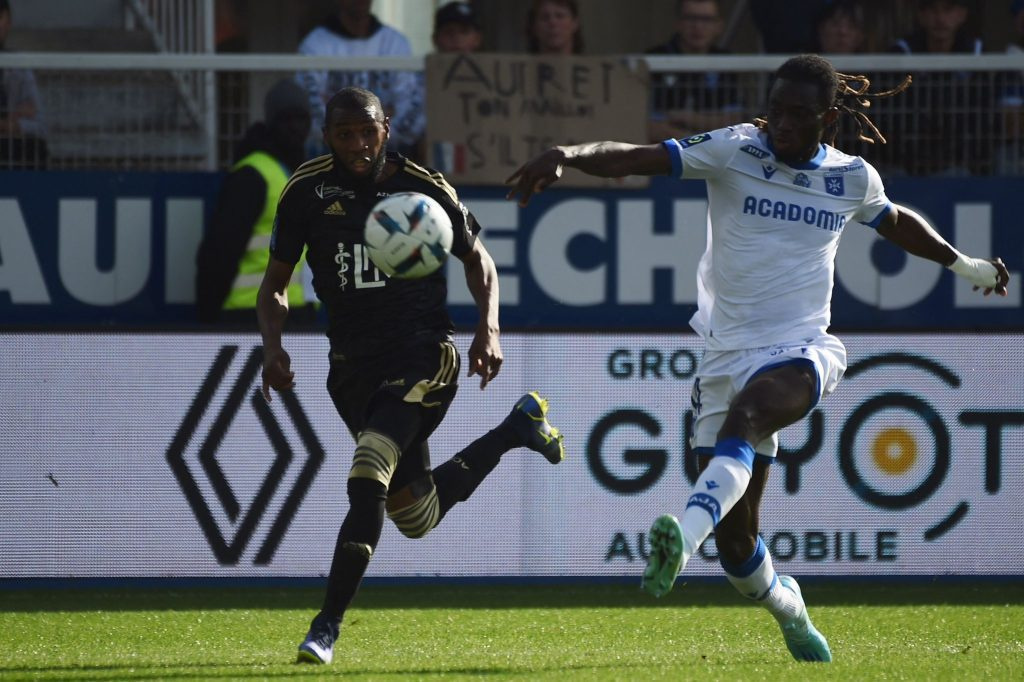 Gideon Mensah (in white jersey) battles with his opponent to keep possession of the ball