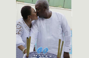 Mahama kisses his wife, Lordina as they cut his 60th birthday cake