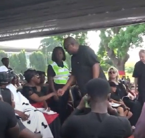 John Mahama in a handshake with a relative of Atsu