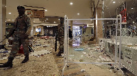 Soldiers patrol inside a trashed shopping mall in Soweto, near Johannesburg