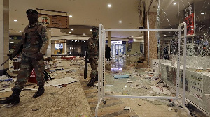 Soldiers patrol inside a trashed shopping mall in Soweto, near Johannesburg