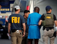 A photo of some FBI agents with a suspect