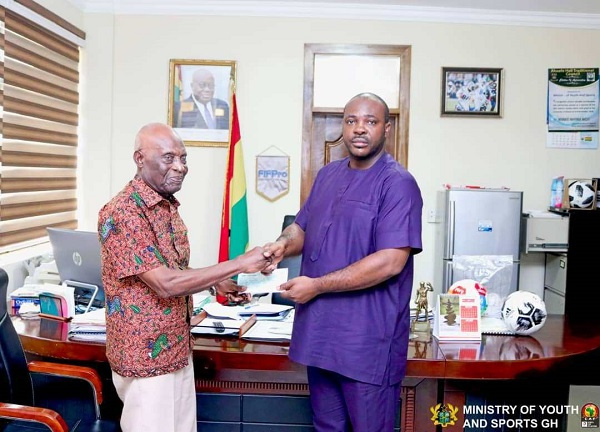 Sports Minister, Isaac Asiamah  presenting the cash to Dr Kwamena Oboe Quansah