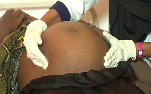 A nurse examining a pregnant woman